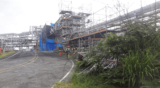 Andamio montado con lona de confinamiento alrededor de un equipo de proceso en una planta industrial