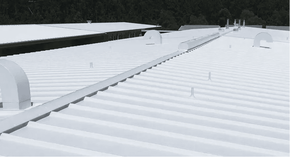 Cubierta metálica de una nave industrial sellada con impermeabilizante blanco